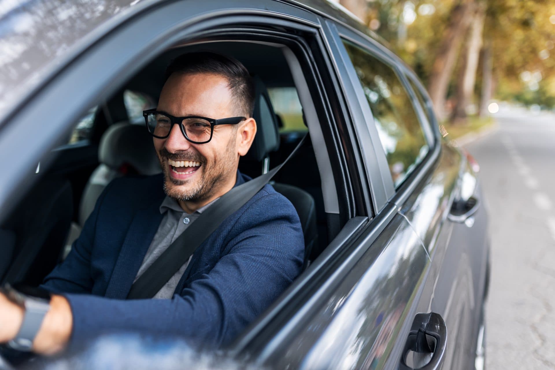 Conductor AXA sonriendo al volante de su coche